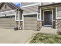 Spacious three-car garage with stone accents and a welcoming front entrance at 3508 Silverado Cir, Frederick, CO 80516