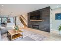 Spacious living room with modern fireplace, hardwood floors, and an open staircase at 3911 Mariposa St, Denver, CO 80211