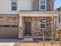 Inviting front entrance showcasing a stone facade, a covered porch, and a stylish front door at 564 Red Rock Pl, Brighton, CO 80601