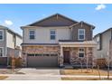 Charming two-story home featuring stone accents, a two-car garage, and a cozy front porch at 564 Red Rock Pl, Brighton, CO 80601