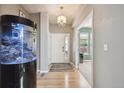 Bright entryway featuring hardwood floors, a modern chandelier, and a unique fish tank at 14049 Detroit Dr, Thornton, CO 80602