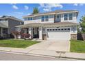 Charming two-story home with a landscaped front yard, covered porch, and a two-car garage at 14049 Detroit Dr, Thornton, CO 80602