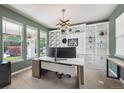 Stylish home office with custom built-ins, large windows, and ample natural light at 14049 Detroit Dr, Thornton, CO 80602