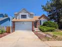 Two-story home featuring a two-car garage, brick accents, and landscaped yard at 20391 E 42Nd Ave, Denver, CO 80249