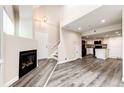 Open living room and kitchen with a fireplace, wood-style floors, and natural light at 17004 E Tennessee Dr # 212, Aurora, CO 80017