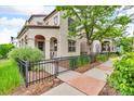 View of the side yard that has a walkway with greenery and a wrought iron fence and sitting area at 3372 Central Park Blvd, Denver, CO 80238