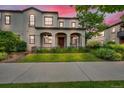 Charming two-story stucco home boasts a covered porch, manicured lawn, and inviting curb appeal at sunset at 3372 Central Park Blvd, Denver, CO 80238