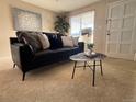 Living room with black leather sofa and unique coffee table at 1496 S Pierson St # 116, Denver, CO 80232