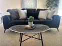 Bright living room featuring a modern sofa with stylish pillows and a unique accent table at 1496 S Pierson St # 116, Denver, CO 80232