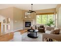 Cozy living room with fireplace, neutral decor, and a large window offering plenty of natural light at 2940 Ulster St, Denver, CO 80238