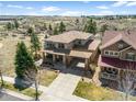 Expansive aerial view of a home with a portico, golf course views, and mature trees at 12119 S Wanderlust Way, Parker, CO 80138