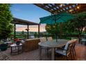 Outdoor dining area with pergola, featuring a table with umbrella and comfortable seating with sunset views at 12119 S Wanderlust Way, Parker, CO 80138