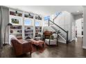 Cozy living room with custom built-ins, a decorative staircase, and stylish furnishings at 12119 S Wanderlust Way, Parker, CO 80138