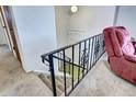 View of the staircase landing with a unique wrought iron railing and a chair visible at 301 S Troy St, Aurora, CO 80012
