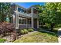 Charming two-story home with a pergola-covered porch, lush landscaping, and a well-maintained lawn at 11300 Night Heron Dr, Parker, CO 80134