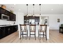 Kitchen island with pendant lighting, white countertops, and seating for casual dining at 771 Dutton Ct, Castle Rock, CO 80104