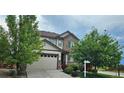 Charming two-story home featuring a two-car garage, beautiful stone accents, and mature trees in the front yard at 22336 E Bellewood Dr, Aurora, CO 80015