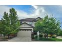 Inviting two-story home with a two-car garage, stone accents, and mature trees in a well-maintained neighborhood at 22336 E Bellewood Dr, Aurora, CO 80015