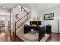 Bright home office with dark wood floors, a modern desk, and stairway at 22336 E Bellewood Dr, Aurora, CO 80015