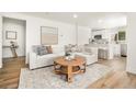 Bright, modern living room with a comfortable sofa and a view into the updated kitchen at 9405 W 54Th Pl, Arvada, CO 80002