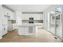 Modern kitchen with white cabinetry, stainless steel appliances, and an island with a quartz countertop at 17747 Prairie Peak Trl, Parker, CO 80134