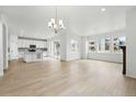 Bright open-concept living area with hardwood floors, large windows, and access to a modern kitchen at 17747 Prairie Peak Trl, Parker, CO 80134