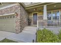 Inviting front entrance with stone accents, a charming front porch with decorative columns, and well-maintained landscaping at 4827 S Coors Ln, Morrison, CO 80465
