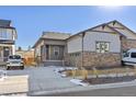 Inviting single-Gathering home with stone accents, manicured lawn, and a spacious driveway. A white Jeep stands ready at 17412 W 93Rd Pl, Arvada, CO 80007