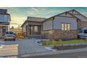 Charming single-Gathering home with stone accents, manicured lawn, and a spacious driveway. A white Jeep stands ready for adventure at 17412 W 93Rd Pl, Arvada, CO 80007