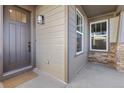Charming front entrance with a gray door, exterior lighting, and stone accents on the porch at 17412 W 93Rd Pl, Arvada, CO 80007