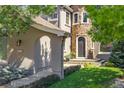 Arched entry features a stone tower with arched doorway, stone details and blue flower pots at 2980 Craig Ct, Castle Rock, CO 80109