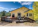 Charming home with a welcoming porch and beautiful landscaping, set against a backdrop of lush greenery at 2785 Magpie Ln, Larkspur, CO 80118