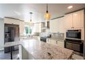 Bright kitchen with stainless steel appliances, white cabinets, and a large island at 17863 Fringed Sage Way, Parker, CO 80134