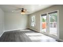 Sunlit living area with hardwood floors and patio access to outdoor deck at 17863 Fringed Sage Way, Parker, CO 80134