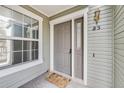 Charming entrance with a gray door, decorative hardware, and a welcoming doormat next to a window at 6776 S Ivy St # B5, Centennial, CO 80112