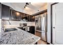 Modern kitchen features dark cabinets, granite countertops, stainless steel appliances, and subway tile backsplash at 6776 S Ivy St # B5, Centennial, CO 80112