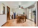 Open dining room featuring hardwood floors, a ceiling fan, and sliding glass doors to the backyard at 6458 W Clifton Pl, Littleton, CO 80128