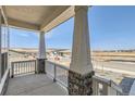 Covered porch view showcasing stone pillars and a glimpse of the neighborhood landscape at 423 Basin Daisy St, Castle Rock, CO 80104