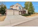 Inviting two-story home with a two-car garage, brick accents, and lush landscaping on a sunny day at 8898 Chestnut Hill Ct, Highlands Ranch, CO 80130