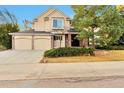 Inviting two-story home with a two-car garage, brick accents, and lush landscaping on a clear day at 8898 Chestnut Hill Ct, Highlands Ranch, CO 80130