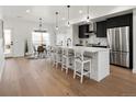 Bright kitchen with black cabinets, stainless steel appliances, and a large center island with seating at 4539 Tabor St, Wheat Ridge, CO 80033