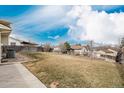Expansive backyard with lush green grass, mature trees, and a sturdy fence providing privacy and space to enjoy at 18835 E Utah Cir, Aurora, CO 80017
