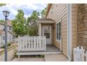 Cozy front porch with white picket fence and neutral siding offers a welcoming entrance to this charming home at 8463 Everett Way # B, Arvada, CO 80005