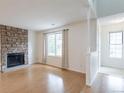 Bright living room with hardwood floors, a stone fireplace, and large windows, creating a warm and inviting atmosphere at 8463 Everett Way # B, Arvada, CO 80005