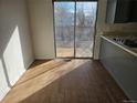 A cozy dining room featuring sliding glass doors to an outdoor deck, laminate flooring, and lots of natural light at 4582 Frankfort Way, Denver, CO 80239