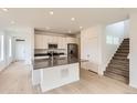 Open-concept kitchen with white cabinets, stainless appliances, and large center island at 6740 Juniper Dr, Thornton, CO 80602
