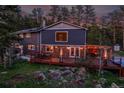Beautiful two-story home with stone accents and outdoor deck overlooking a lush, wooded landscape at 4574 Picutis Rd, Indian Hills, CO 80454