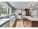 Bright kitchen features granite counters, stainless steel appliances, and a large island with a breakfast bar at 4574 Picutis Rd, Indian Hills, CO 80454