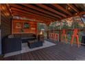 Outdoor patio seating area with fire pit and wood plank patio at 4574 Picutis Rd, Indian Hills, CO 80454