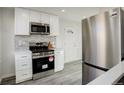 Contemporary kitchen featuring stainless steel appliances, white cabinets, and stylish backsplash at 4835 Grove St, Denver, CO 80221